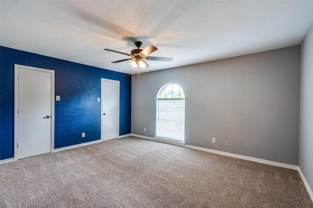 spare room with baseboards, ceiling fan, and carpet flooring