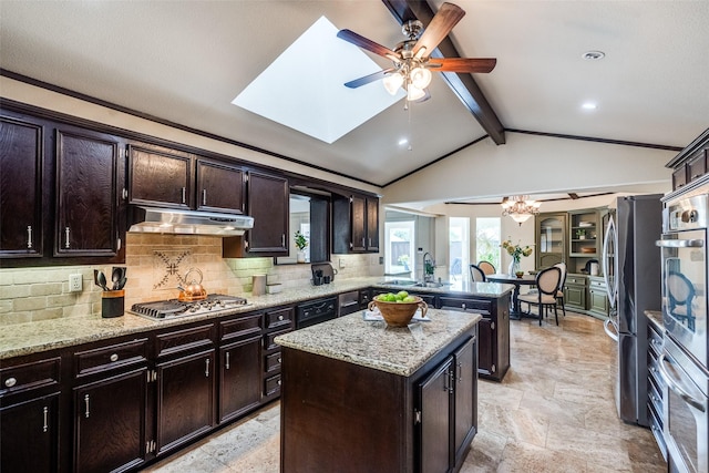 kitchen with under cabinet range hood, stainless steel appliances, ceiling fan, and decorative backsplash