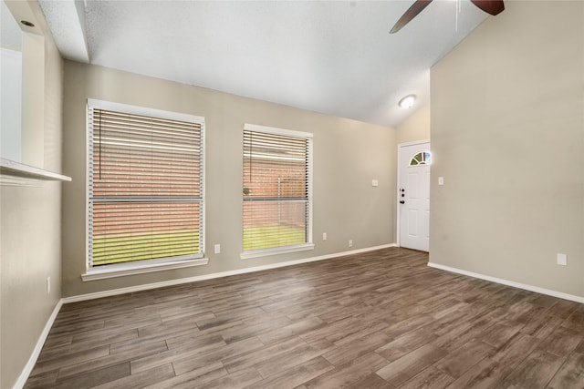 unfurnished living room featuring baseboards, plenty of natural light, a ceiling fan, and wood finished floors