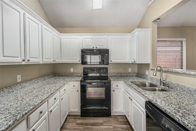 kitchen with dark wood-style floors, a textured ceiling, white cabinets, a sink, and black appliances