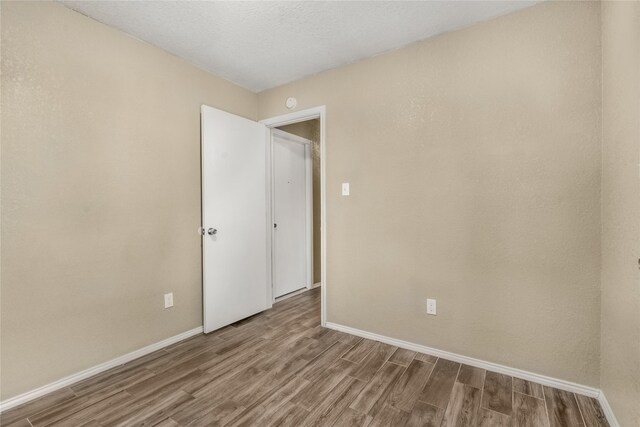 empty room featuring baseboards and wood finished floors