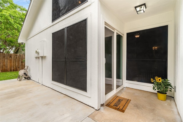 property entrance with a patio and fence