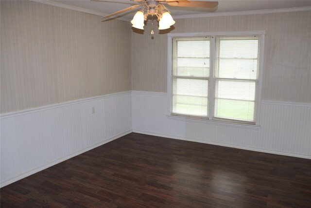 unfurnished room with a wainscoted wall, ceiling fan, ornamental molding, and dark wood finished floors