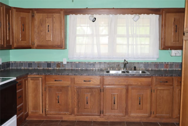 kitchen featuring brown cabinets, black / electric stove, and a sink