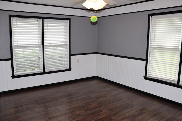 unfurnished room with a ceiling fan, wainscoting, and wood finished floors