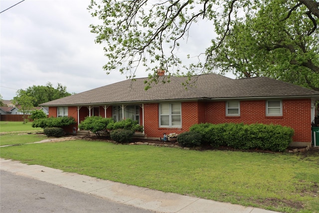 single story home with roof with shingles, a chimney, a front lawn, and brick siding