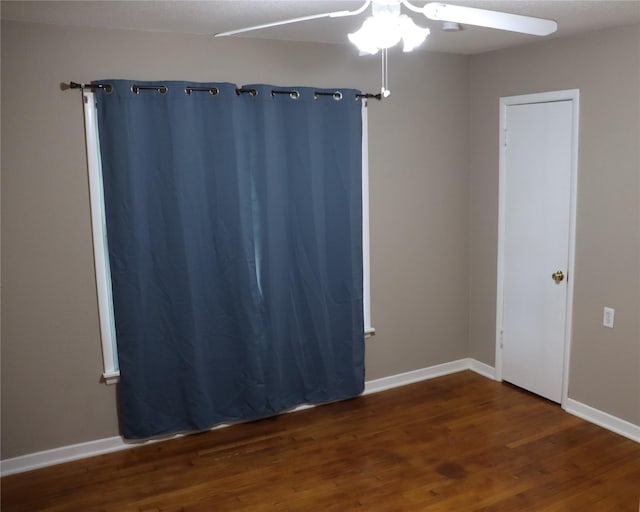 unfurnished room featuring a ceiling fan, baseboards, and wood finished floors