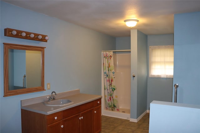 full bathroom featuring vanity, baseboards, tile patterned floors, and a stall shower