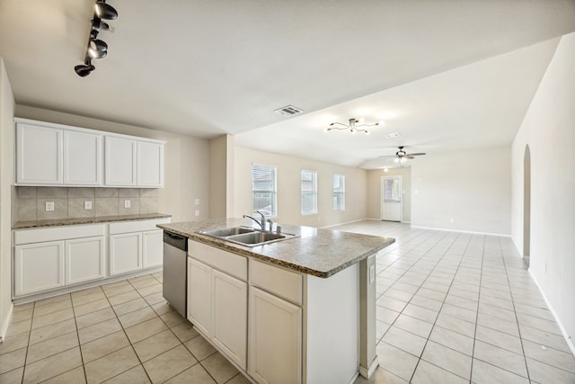 994 Decker Dr, Fate, TX 75189 - kitchen featuring a sink, light tile patterned flooring, stainless steel dishwasher, decorative backsplash, and arched walkways