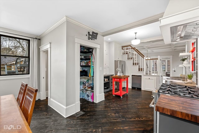 kitchen featuring crown molding, wood finished floors, a sink, baseboards, and wood counters