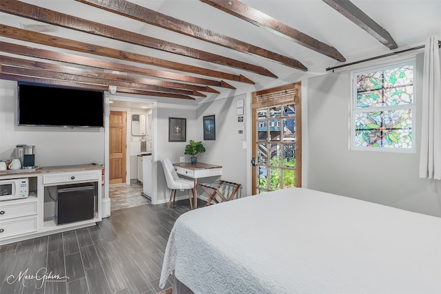 bedroom featuring ensuite bathroom, dark wood-style flooring, beam ceiling, and multiple windows