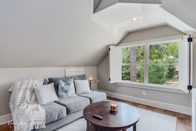 living room featuring baseboards and lofted ceiling
