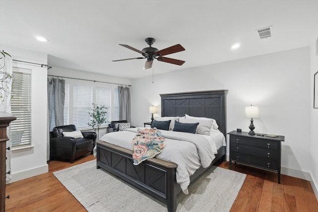 bedroom with ceiling fan, visible vents, wood finished floors, baseboards, and recessed lighting