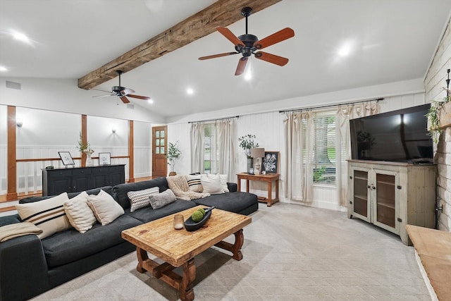living area featuring ceiling fan, lofted ceiling with beams, and a healthy amount of sunlight