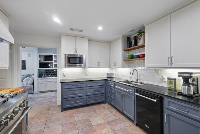 kitchen with visible vents, open shelves, white cabinetry, a sink, and appliances with stainless steel finishes