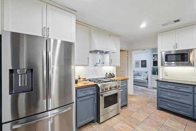 kitchen featuring visible vents, appliances with stainless steel finishes, wooden counters, and tasteful backsplash