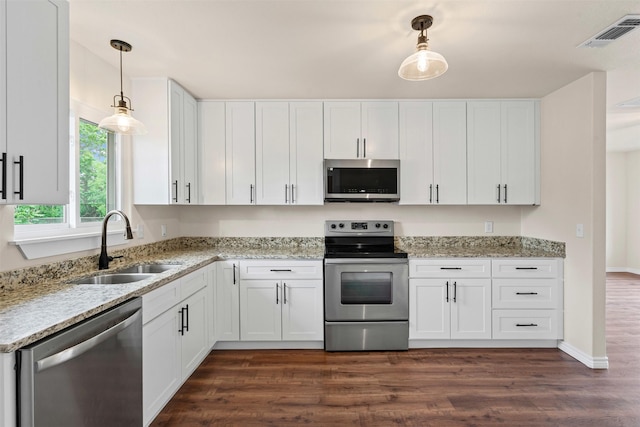 kitchen with a sink, stainless steel appliances, white cabinetry, and visible vents