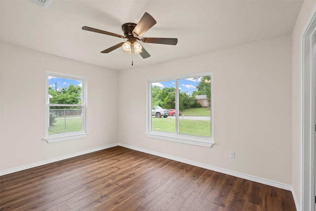 unfurnished room featuring baseboards, ceiling fan, dark wood-style flooring, and visible vents