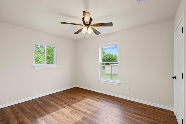 unfurnished bedroom with baseboards, a closet, wood finished floors, and multiple windows