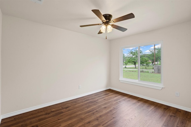unfurnished room with a ceiling fan, baseboards, and dark wood finished floors