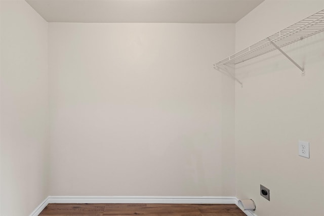 clothes washing area featuring baseboards, laundry area, electric dryer hookup, and wood finished floors
