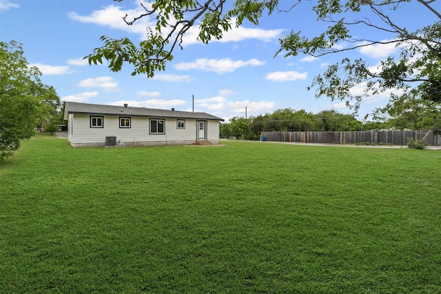 view of yard featuring fence and central AC unit