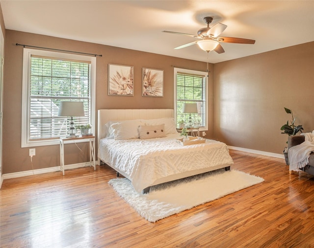 bedroom featuring baseboards, ceiling fan, and wood finished floors