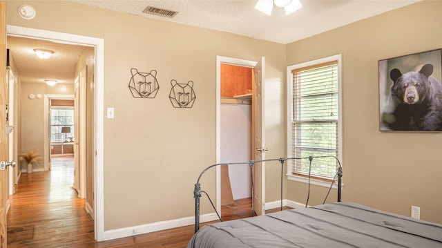 bedroom featuring visible vents, baseboards, wood finished floors, and a closet