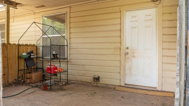 view of exterior entry featuring fence