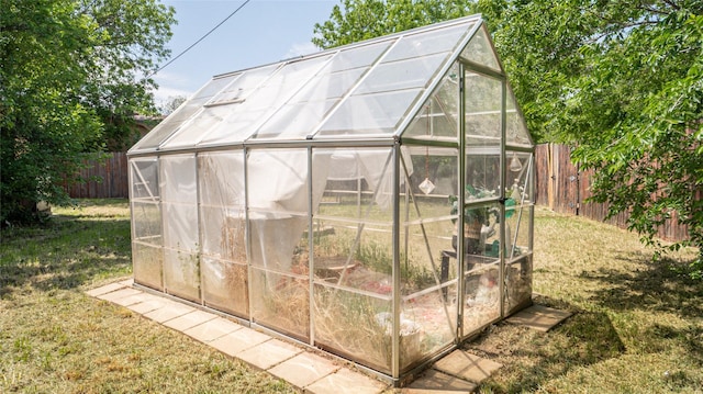 view of greenhouse featuring a lawn and a fenced backyard