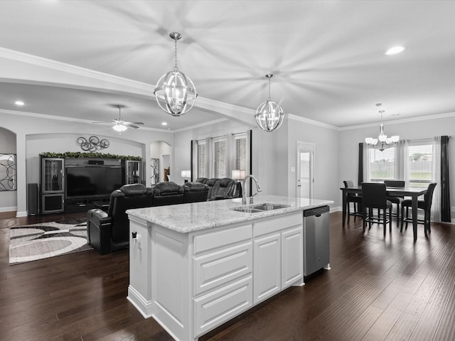 kitchen featuring stainless steel dishwasher, recessed lighting, arched walkways, light stone counters, and a sink