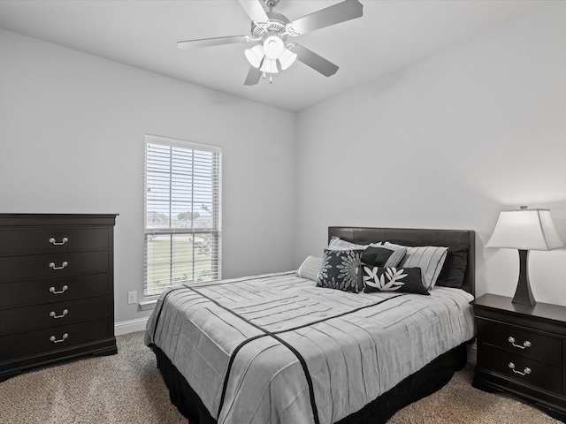 carpeted bedroom featuring baseboards and ceiling fan