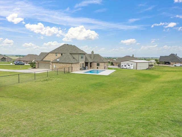 view of yard with an attached garage, a fenced backyard, and driveway