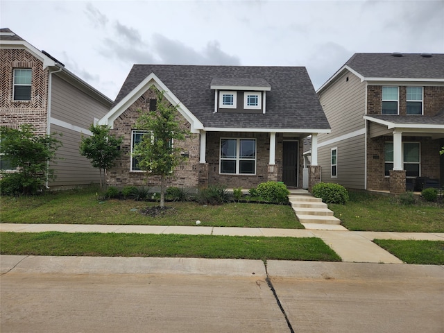 10076 Travis Dr, Providence Village, TX 76227 - craftsman house featuring brick siding, a shingled roof, and a front yard