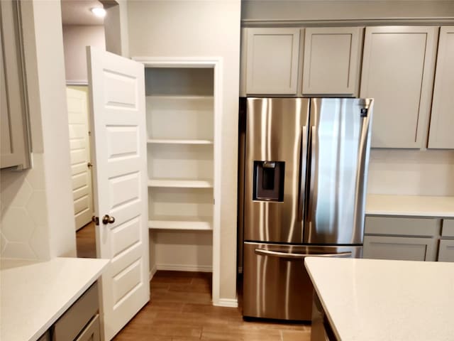 10076 Travis Dr, Providence Village, TX 76227 - kitchen with light countertops, stainless steel fridge, gray cabinets, and light wood-type flooring