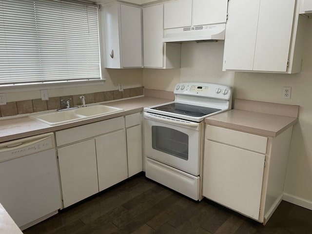 kitchen with dark wood-style flooring, a sink, white cabinets, under cabinet range hood, and white appliances