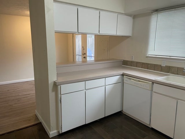 kitchen with a sink, dishwasher, light countertops, white cabinetry, and dark wood-type flooring