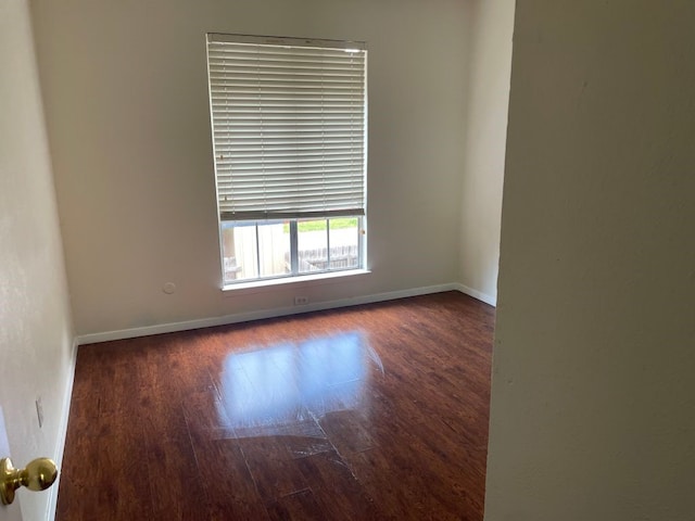 empty room with baseboards and wood finished floors