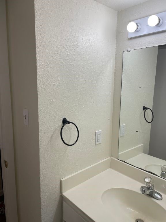 bathroom with vanity and a textured wall