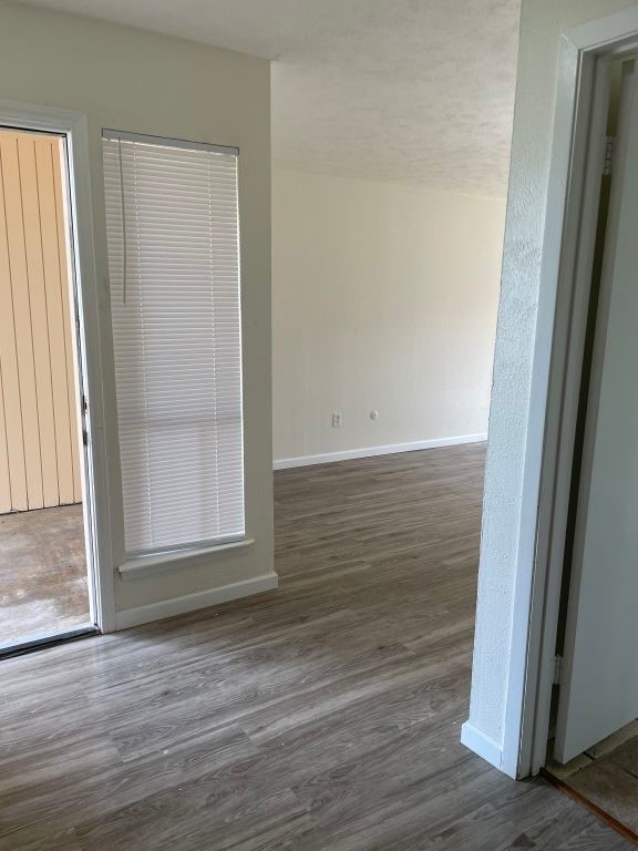 empty room with baseboards and dark wood finished floors