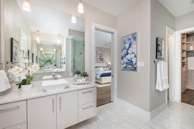 bathroom with vanity, marble finish floor, baseboards, ensuite bathroom, and a stall shower