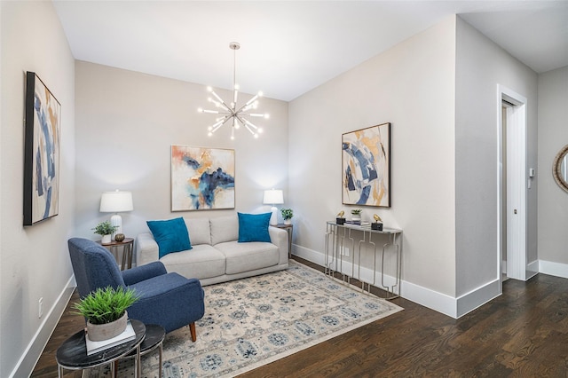 living area with baseboards, wood finished floors, and an inviting chandelier