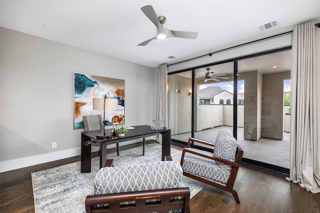 home office featuring visible vents, a ceiling fan, baseboards, and wood finished floors
