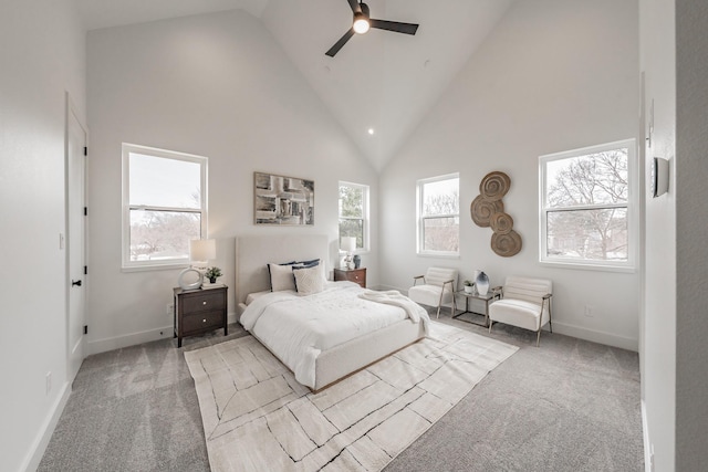 carpeted bedroom featuring high vaulted ceiling, multiple windows, baseboards, and ceiling fan