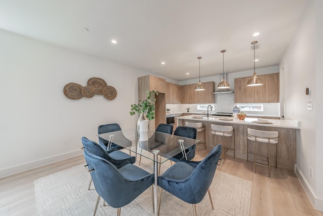 dining room featuring light wood-type flooring, recessed lighting, and baseboards
