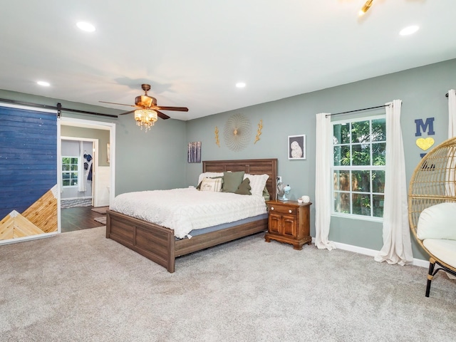 bedroom featuring carpet flooring, recessed lighting, and a barn door