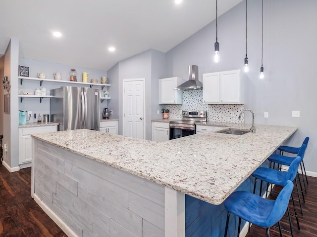kitchen with open shelves, a sink, wall chimney exhaust hood, stainless steel appliances, and vaulted ceiling
