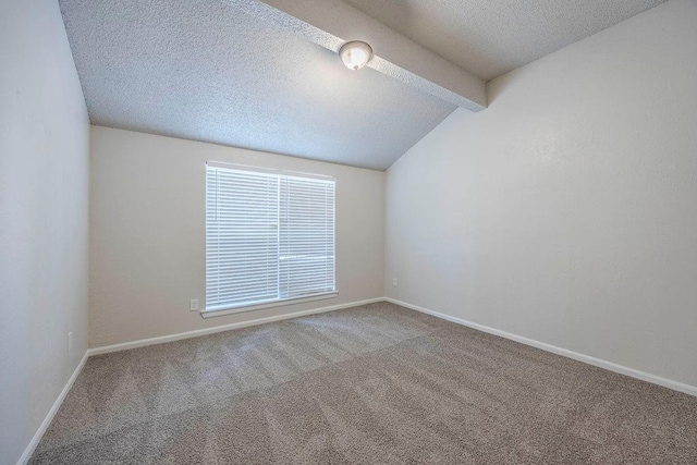 carpeted spare room with vaulted ceiling with beams, a textured ceiling, and baseboards