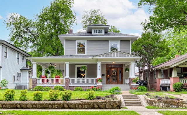 traditional style home featuring central air condition unit, covered porch, and a chimney