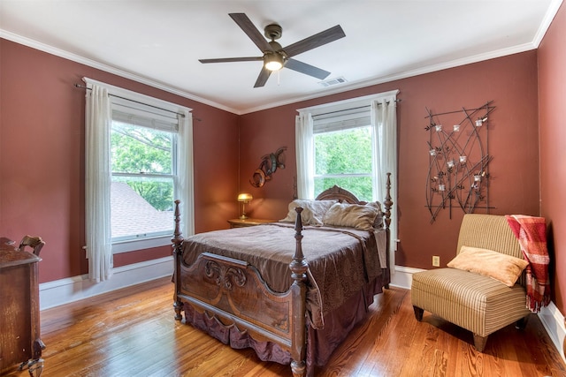 bedroom featuring visible vents, multiple windows, and hardwood / wood-style floors